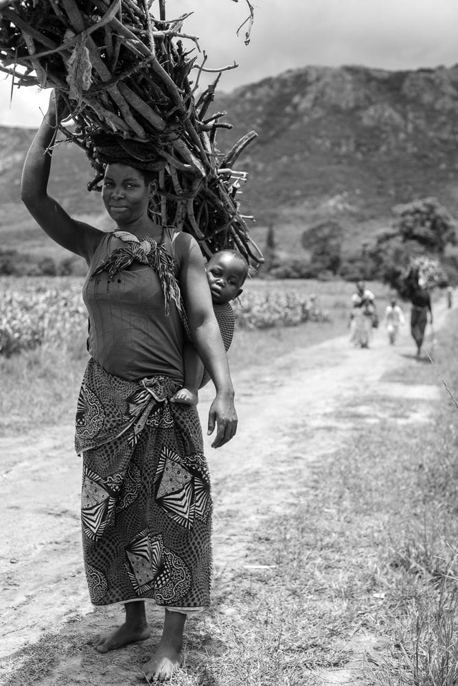 Woman carrying firewood, and her child